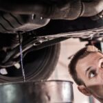 Werkstattarbeit an einem Auto, Ölwechsel und unter der Karosserie.