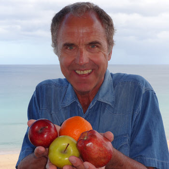 Obst mit Apfel, Orange, und weiteren Früchten in den Händen gehalten.