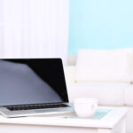 Laptop und Tasse auf einem Tisch