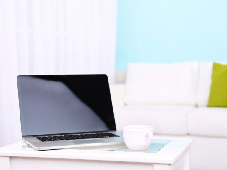 Laptop und Tasse auf einem Tisch