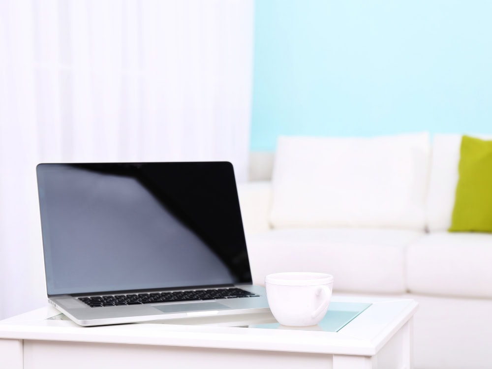 Laptop und Tasse auf einem Tisch