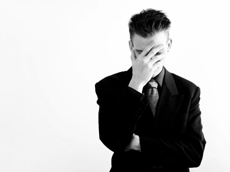 Mann im Anzug, Gesicht bedeckt, nachdenklich