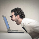 Mann schreit Laptop an