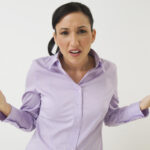 Person in lila Hemd, fragender Gesichtsausdruck