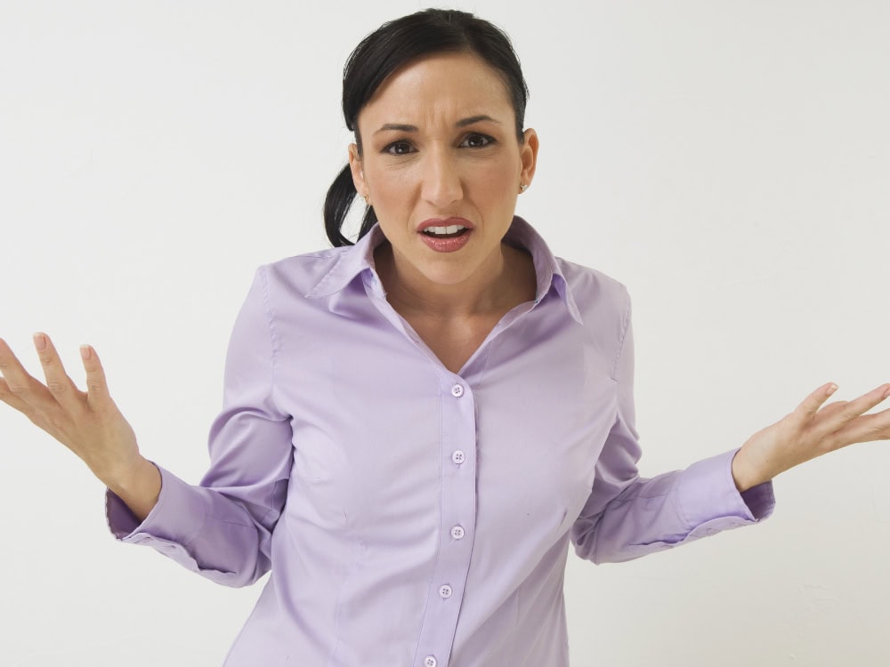 Person in lila Hemd, fragender Gesichtsausdruck