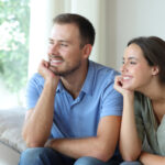 Lächelndes Paar schaut aus dem Fenster.